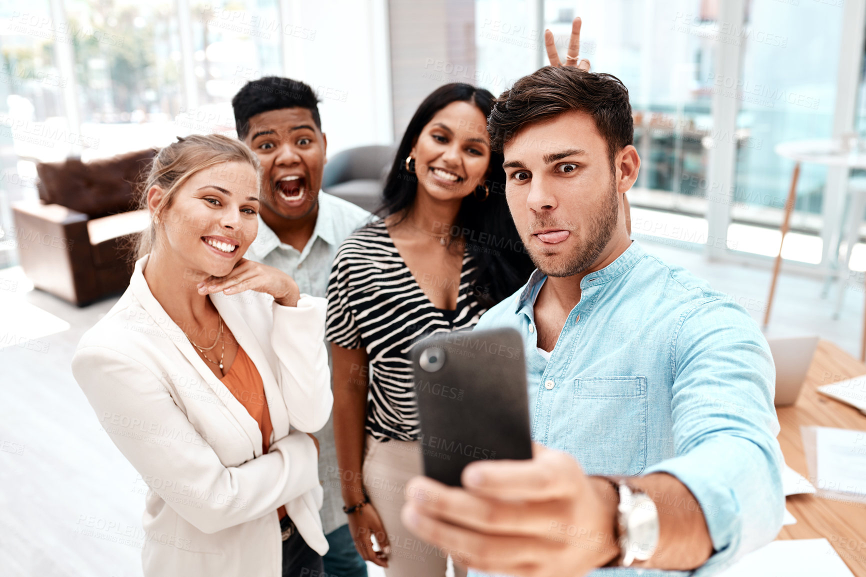 Buy stock photo Cropped shot of a group of young business colleagues taking selfies in their office