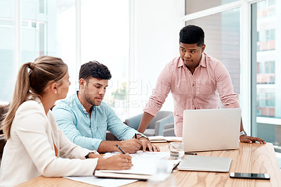 Buy stock photo Cropped shot of three young business colleagues working together in the boardroom