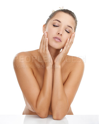 Buy stock photo Cropped shot of a gorgeous young woman touching her face while posing nude against a white background