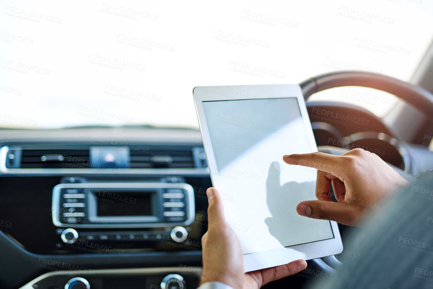 Buy stock photo Cropped shot of an unidentifiable man using a digital tablet while driving a car