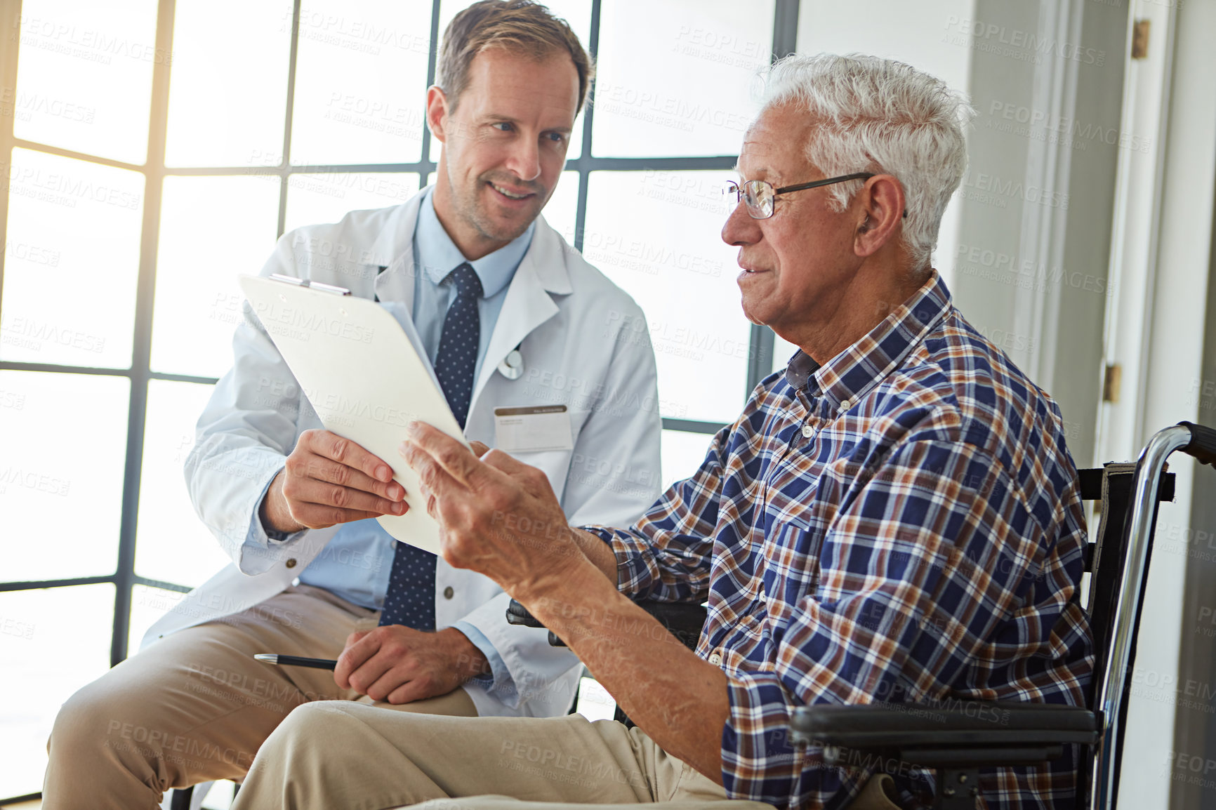 Buy stock photo Cropped shot of a male doctor talking to a senior patient in the retirement home