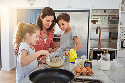 Buy stock photo Cropped shot of a single mother teaching her children how to make pancakes