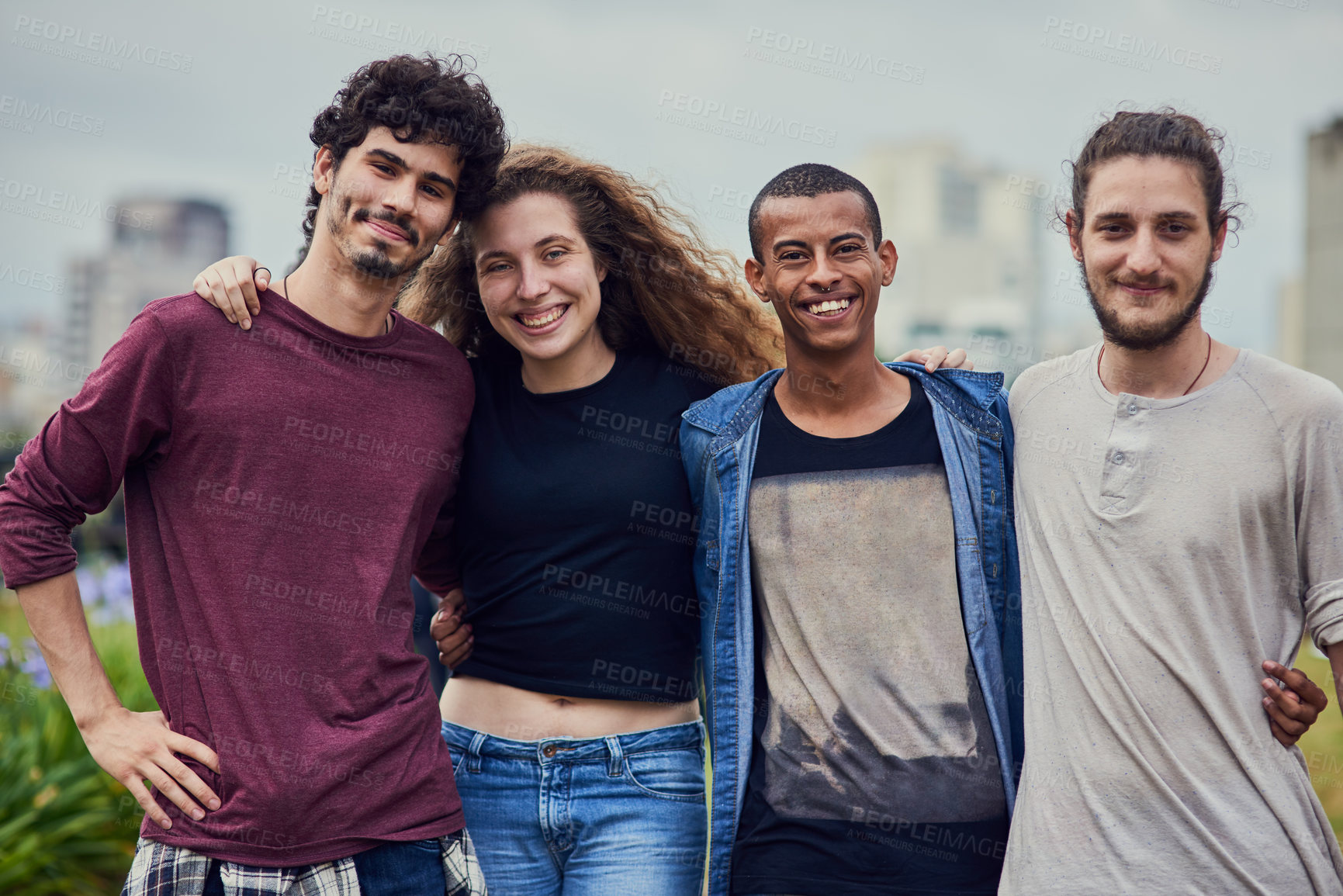 Buy stock photo Portrait of a group of young students standing arms around each other outside in a park during the day