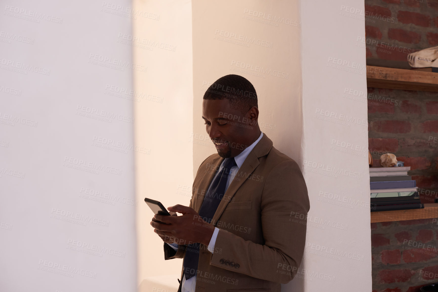 Buy stock photo Shot of a young businessman using a cellphone in an office