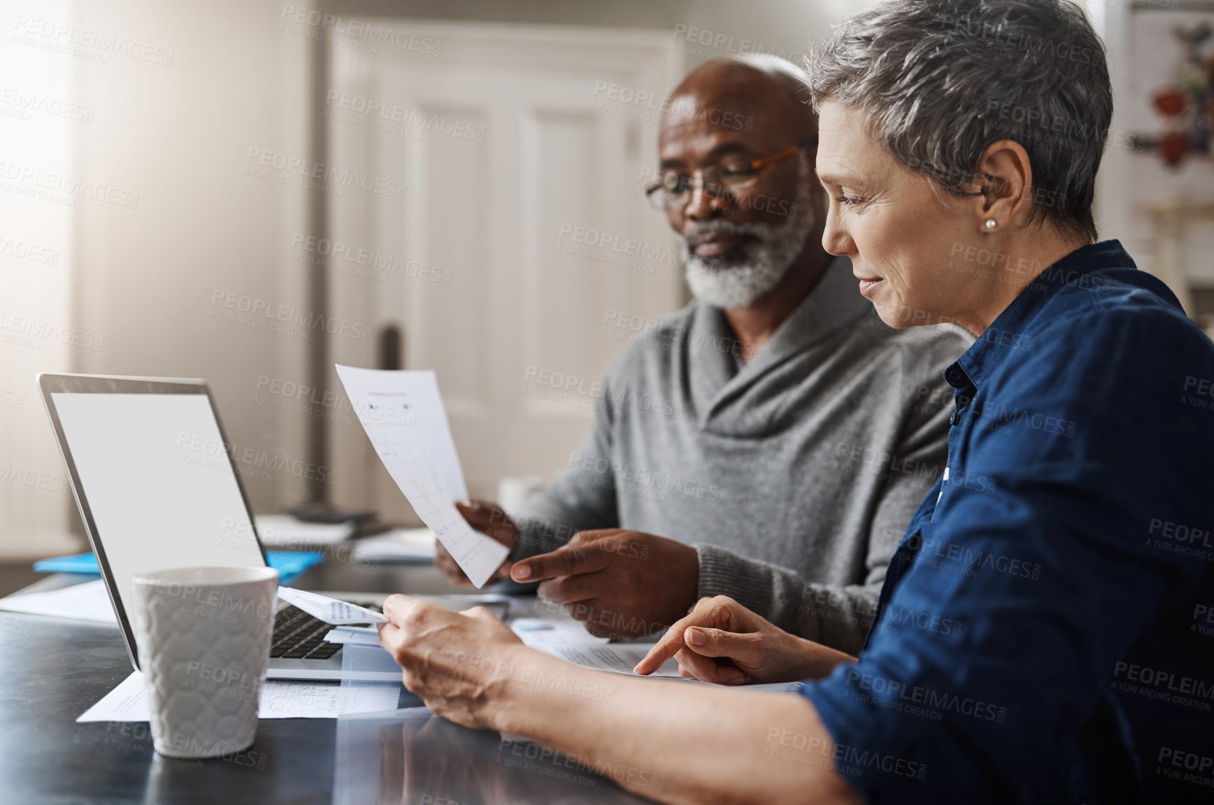 Buy stock photo Shot of a senior couple working on their finances at home