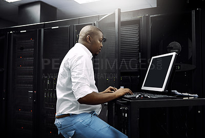 Buy stock photo Cropped shot of an IT technician using a computer while working in the server room of a data center