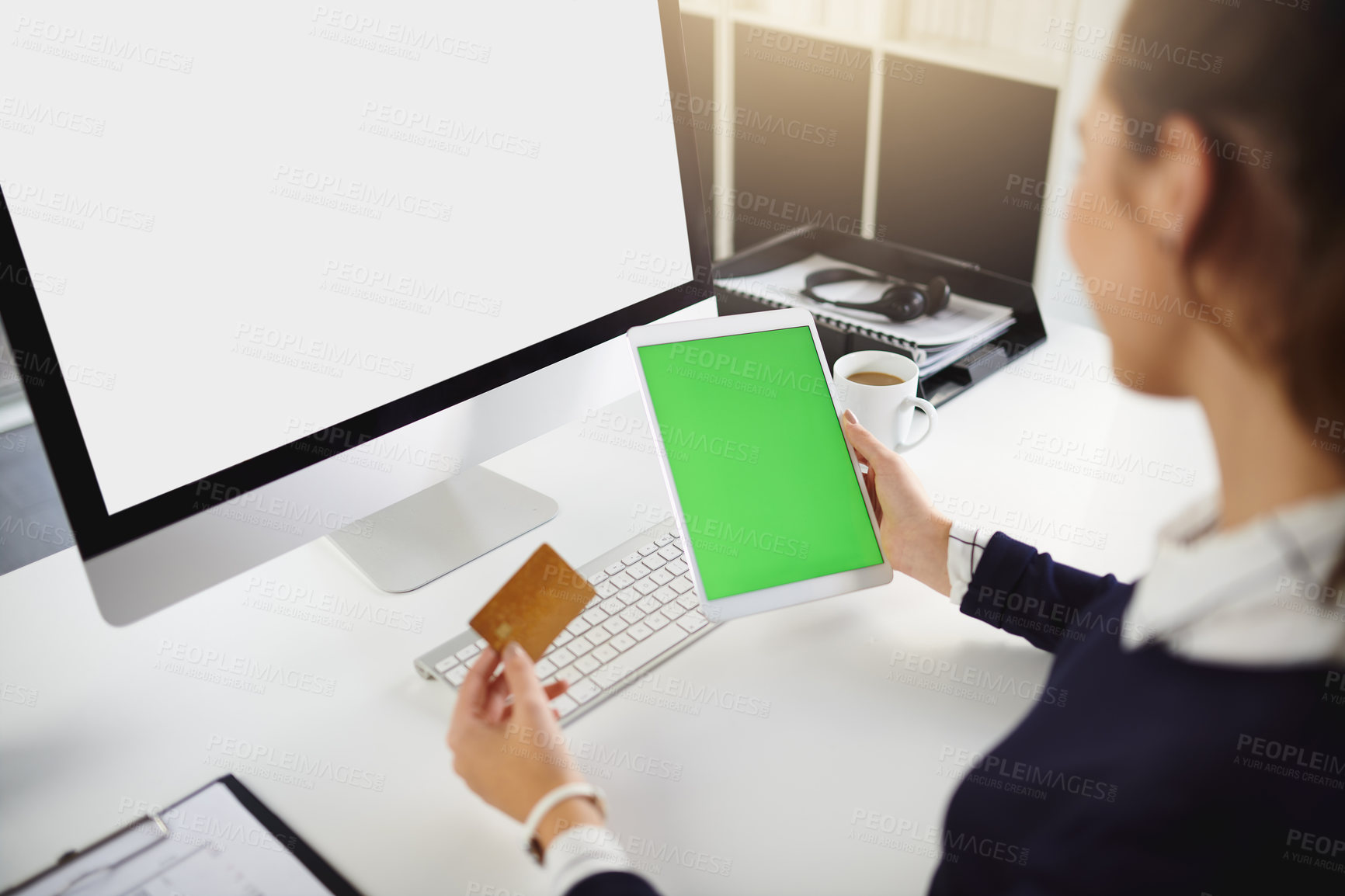 Buy stock photo Rearview shot of an unrecognizable young businesswoman holding a bank card and a tablet in a modern office