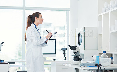Buy stock photo Cropped shot of a focused young female scientist conducting experiments inside of a laboratory during the day