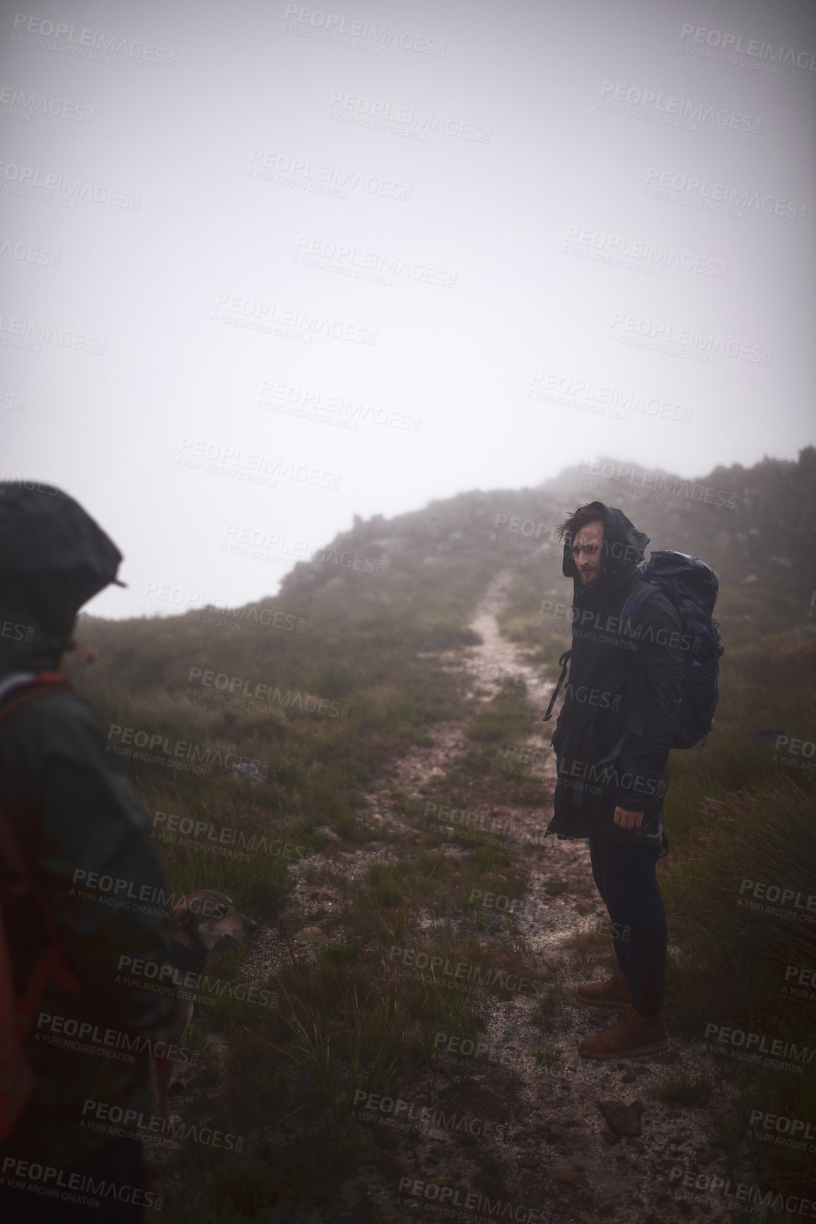 Buy stock photo Shot of two friends out hiking in the mountains on a foggy day