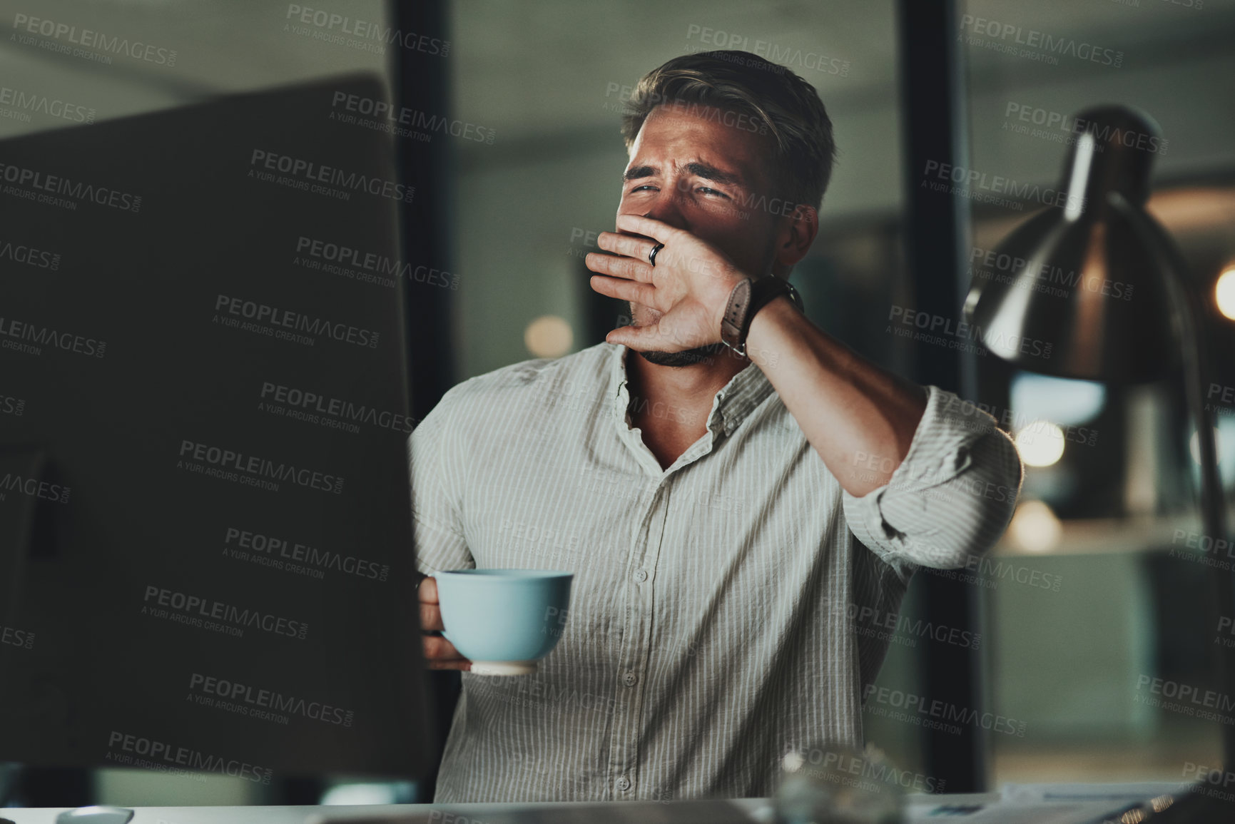 Buy stock photo Coffee, computer and yawn at night with man in office for late evening administration or deadline. Burnout, exhausted and fatigue with tired design employee in creative workplace for online report