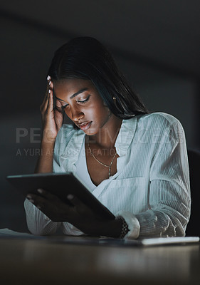 Buy stock photo Shot of a young businesswoman looking stressed out while using a digital tablet in an office at night