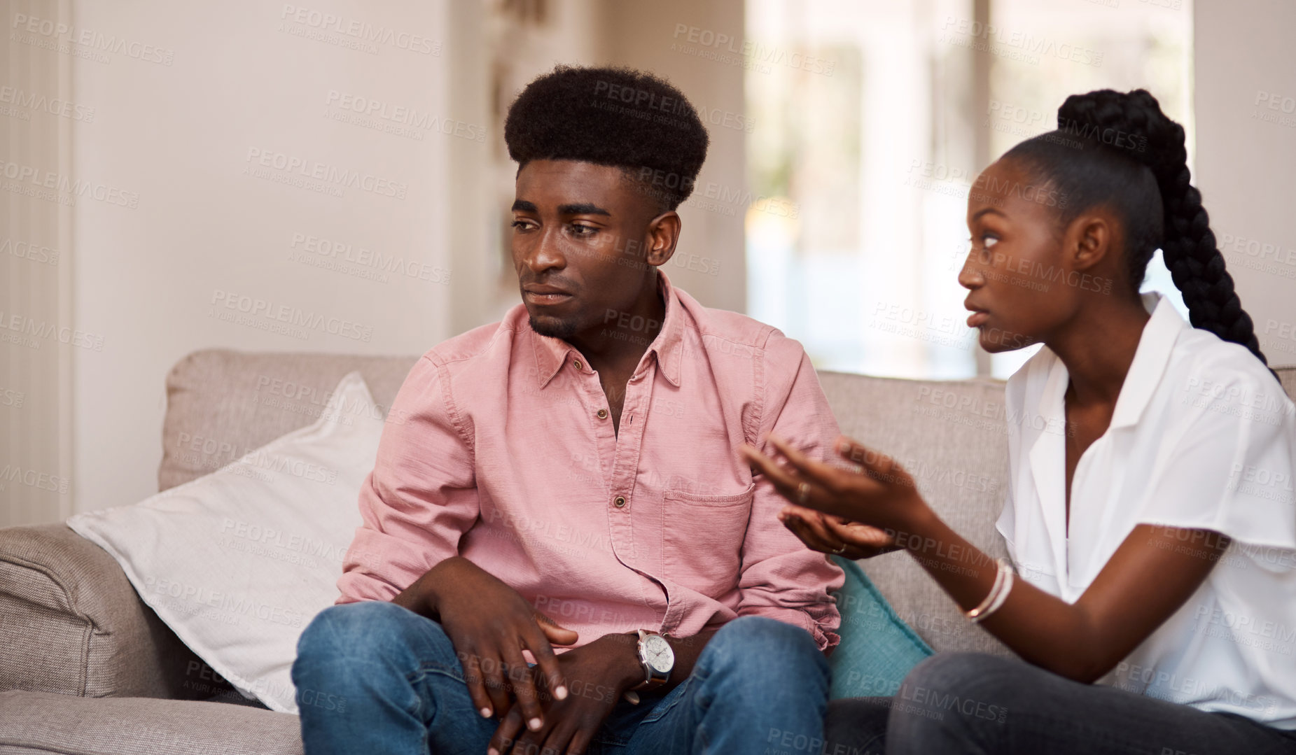 Buy stock photo Cropped shot of a young couple arguing while sitting on the couch at home