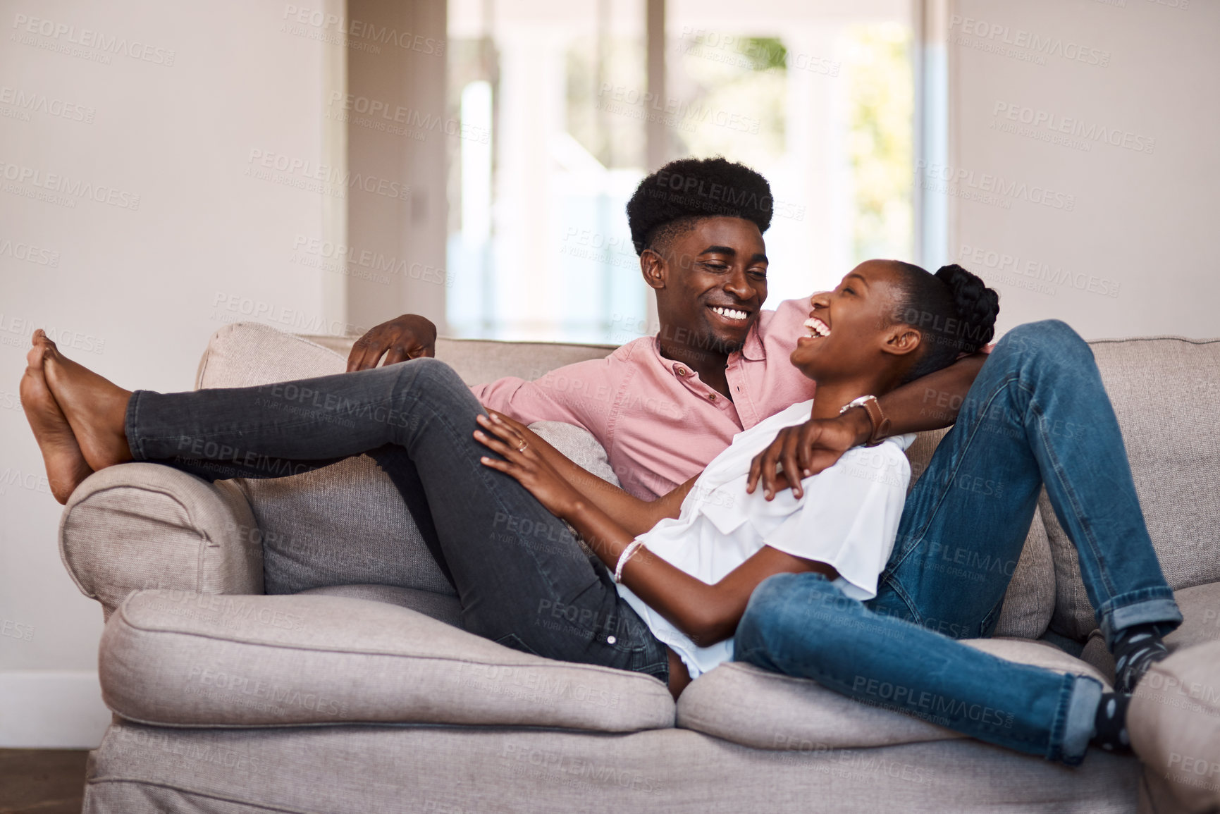 Buy stock photo Shot of a happy young couple relaxing on the sofa at home