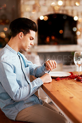 Buy stock photo Romance, waiting and man checking the time while sitting in the restaurant for a valentines day date. Fine dining, late and guy by the table for dinner reservation for anniversary or romantic event.