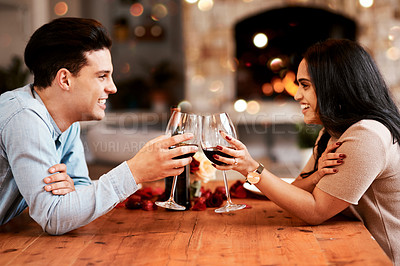 Buy stock photo Love, wine and couple cheers on valentines day date at home with smile, romance and bokeh. Date night, man and woman at table in living room, valentine celebration and happy relationship together.