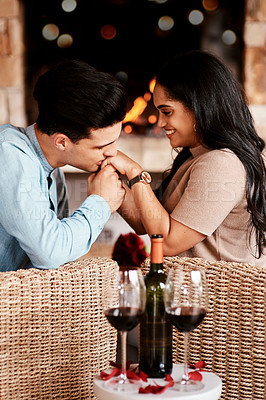 Buy stock photo Young couple on a date, romantic restaurant evening and kiss on the hand at cafe fireplace with wine glasses. Happy people in love, valentines day together and girlfriend smile at handsome boyfriend