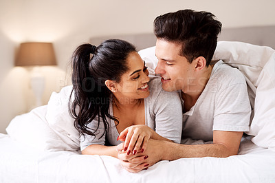 Buy stock photo Bedroom, love and interracial couple together in home holding hands at night. Smile diversity and marriage of an Indian woman and man with love, care and relax happiness with a smile in a house