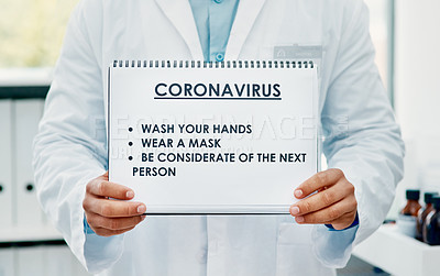 Buy stock photo Shot of a scientist holding a sign with a list of COVID-19 prevention measures on it in a laboratory