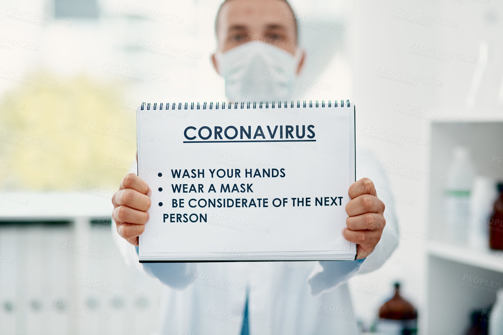 Buy stock photo Shot of a scientist holding a sign with a list of COVID-19 prevention measures on it in a laboratory