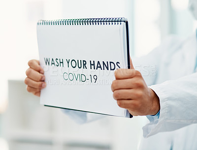Buy stock photo Shot of a scientist holding a sign with “wash your hands” on it in a laboratory