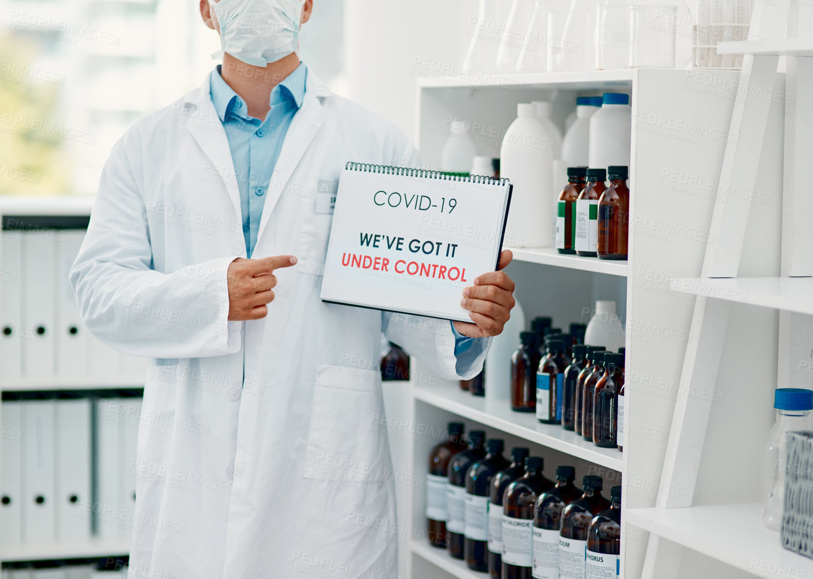 Buy stock photo Cropped shot of a scientist holding a sign with “We’ve got it under control” on it in a laboratory
