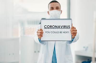 Buy stock photo Shot of a scientist holding a sign with “CORONAVIRUS-YOU COULD BE NEXT” on it in a laboratory