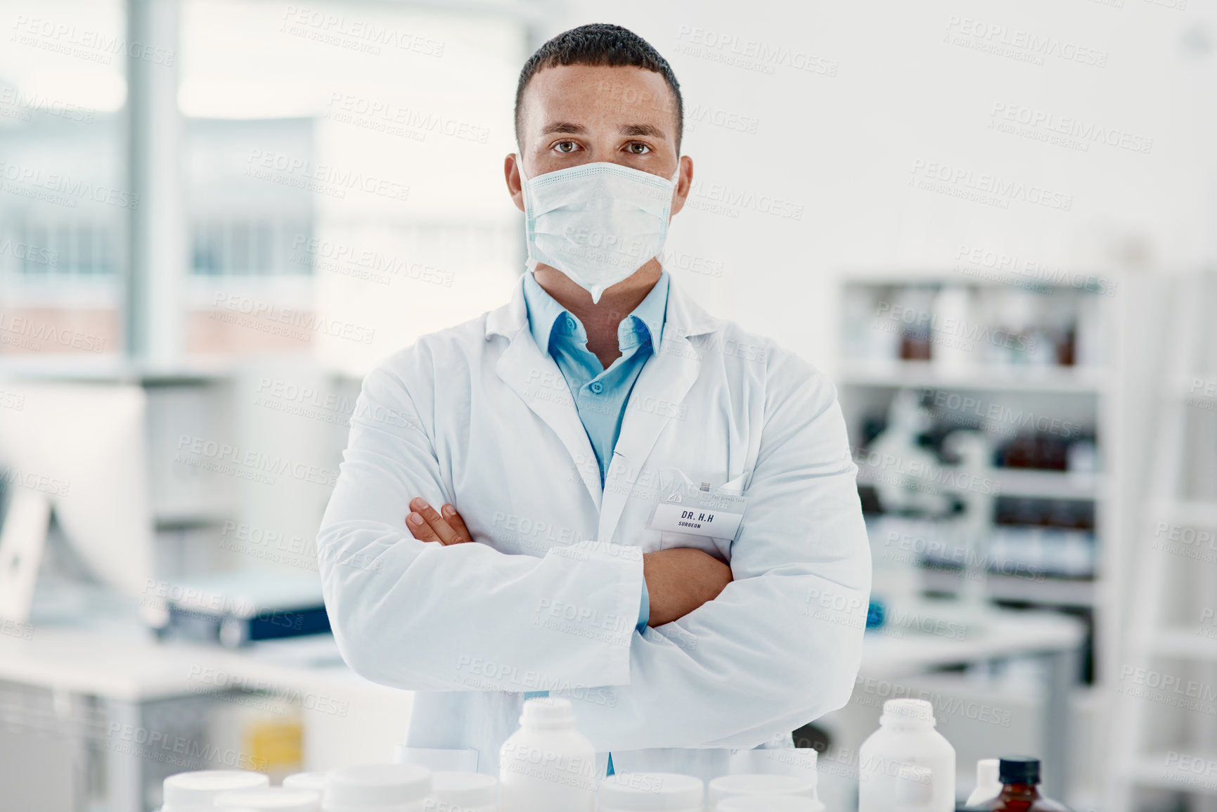 Buy stock photo Portrait of a confident young scientist wearing a mask in a modern laboratory