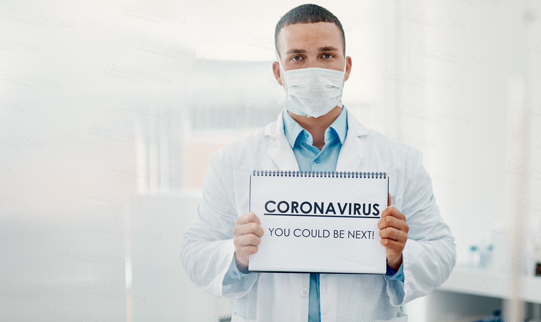 Buy stock photo Shot of a scientist holding a sign with “CORONAVIRUS-YOU COULD BE NEXT” on it in a laboratory