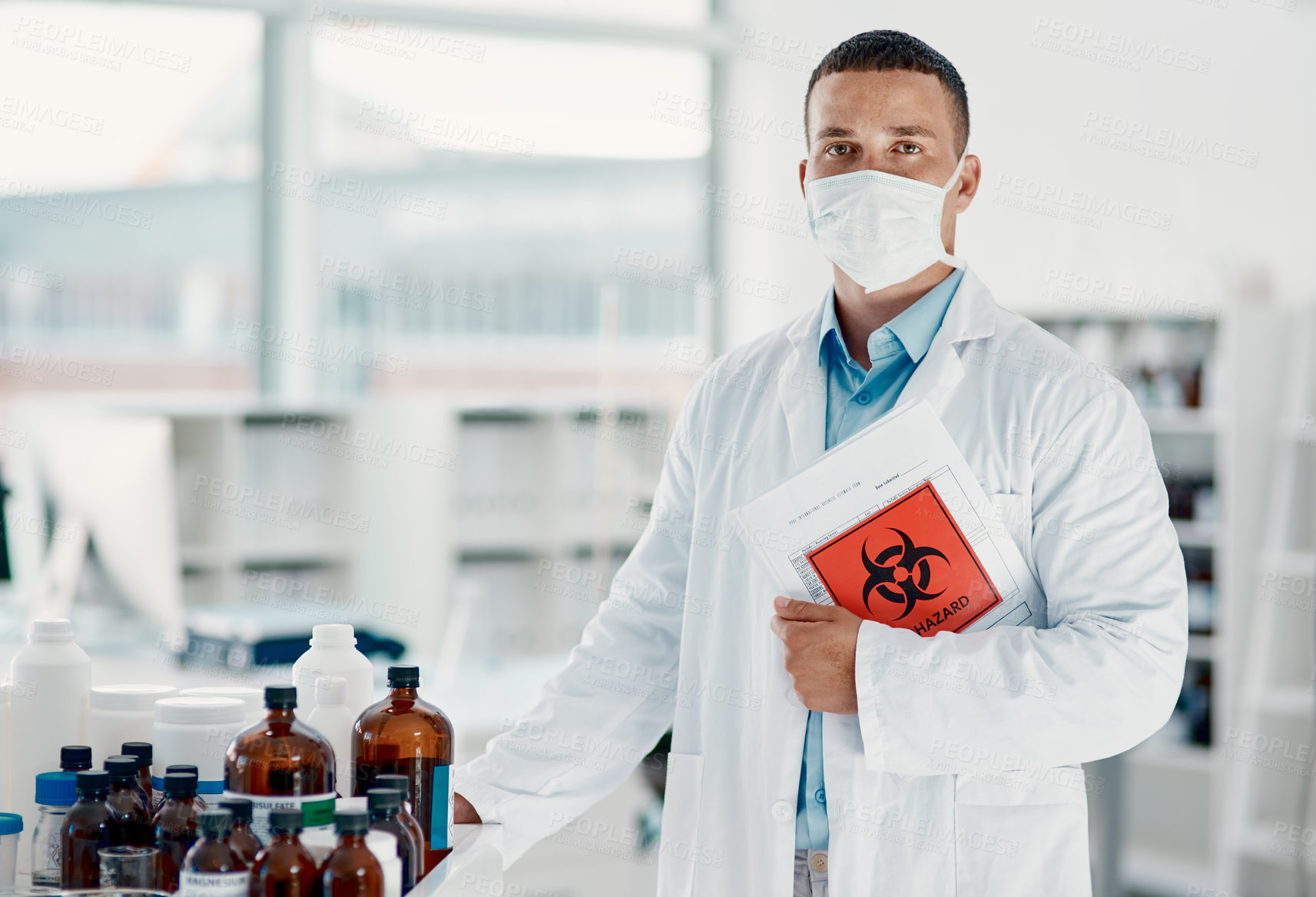 Buy stock photo Portrait of a confident young scientist wearing a mask in a modern laboratory
