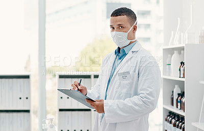 Buy stock photo Portrait of a young scientist writing notes on a clipboard in a laboratory