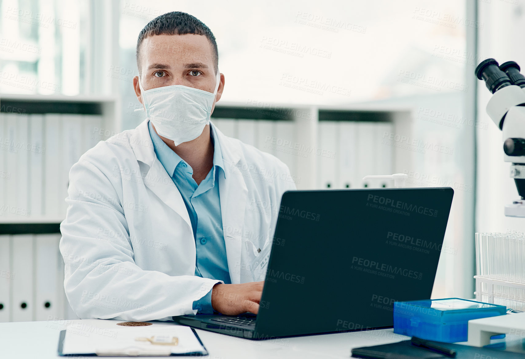 Buy stock photo Portrait of a young scientist using a laptop while working on a coronavirus cure in a laboratory