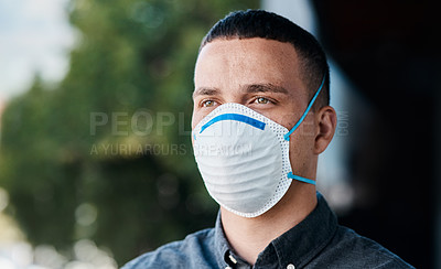 Buy stock photo Shot of a young businessman wearing a mask and standing on the balcony of an office