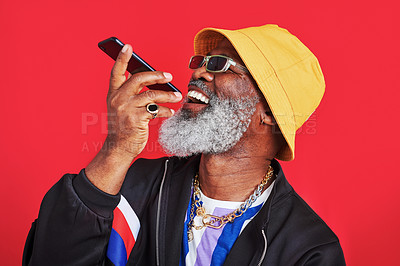 Buy stock photo Studio shot of a mature man holding his cellphone against a red background