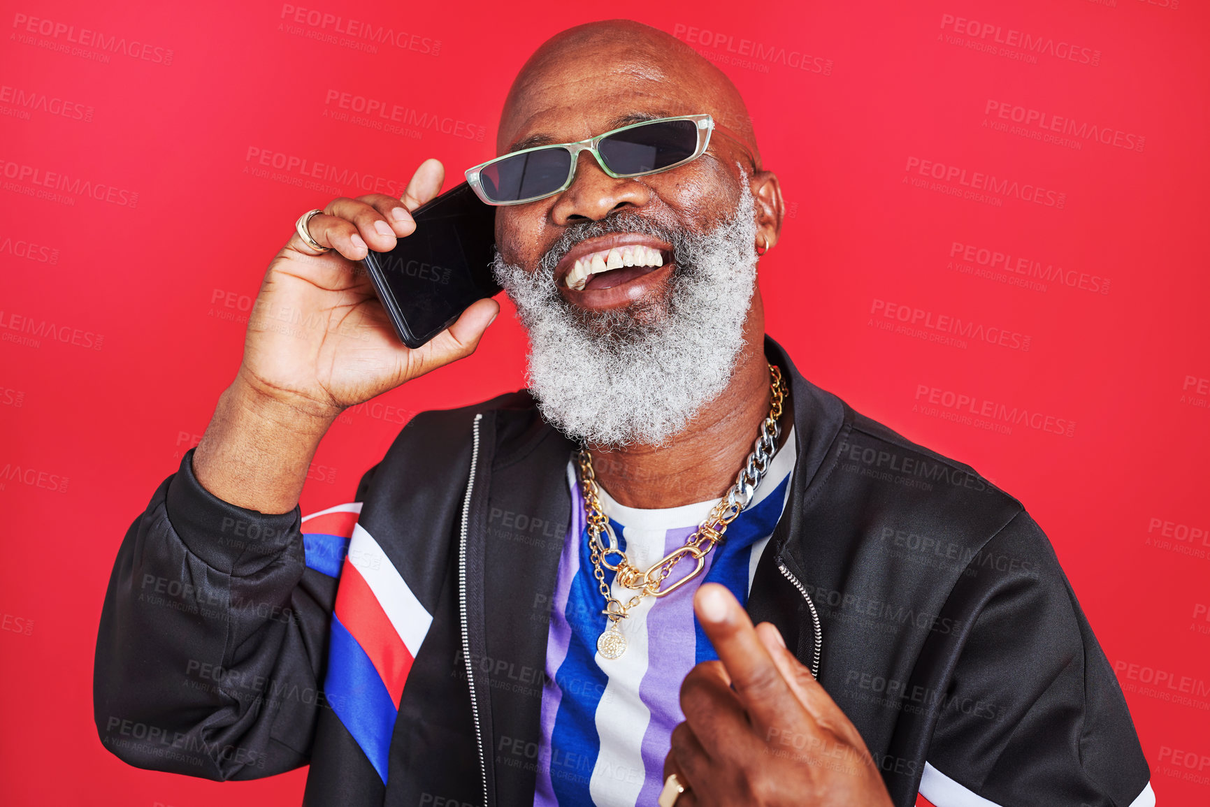 Buy stock photo Senior, black man and laughing with fashion for phone call and communication in studio on red background. Funny joke, vintage and mature African model talking on mobile smartphone for retro style