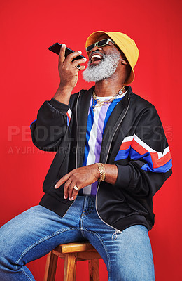 Buy stock photo Studio shot of a mature man using his cellphone against a red background