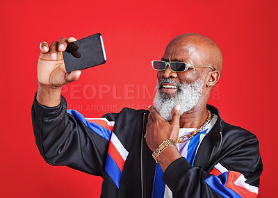 Buy stock photo Studio shot of a senior man taking a selfie against a red background