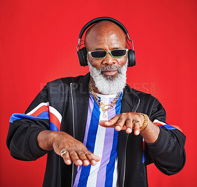 Buy stock photo Senior, dance or black man in headphones in retro fashion for streetwear, trendy sunglasses or radio in studio. African guy, elderly or vintage style on red background with audio track for soul music