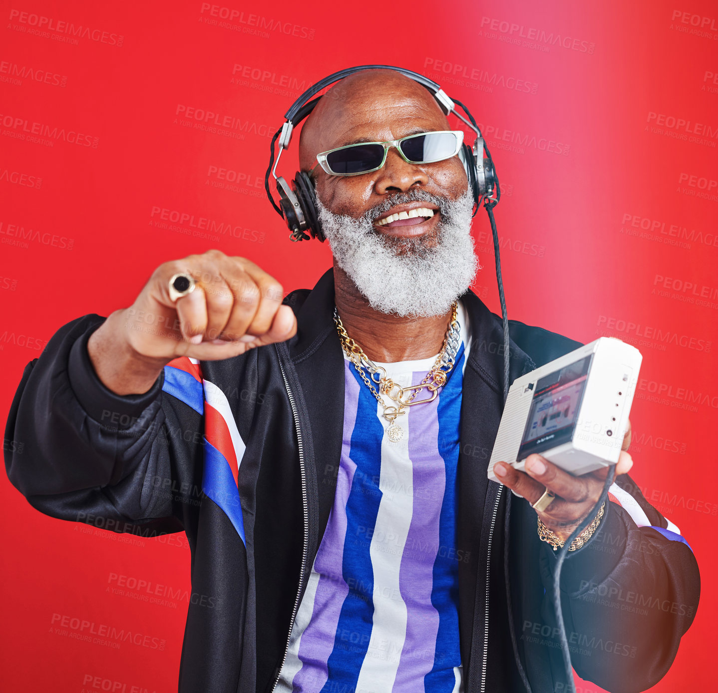 Buy stock photo Senior, happy man or dancing with radio in retro fashion with streetwear, trendy sunglasses in studio. African model, headphones or vintage style on red background with cassette player for soul music