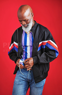 Buy stock photo Senior black man, fashion and sunglasses with vintage style for trendy casual outfit in studio on red background. African person, cleaning lenses and model wiping accessory for cool retro clothes