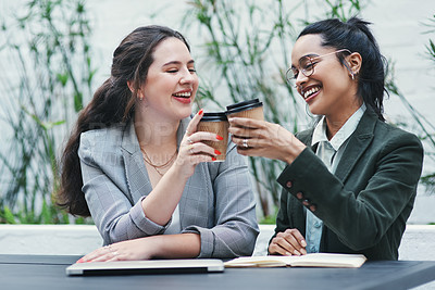 Buy stock photo Shot of two young businesswomen toasting with coffee during a business meeting