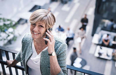 Buy stock photo Shot of a mature businesswoman using a smartphone on the stairs of a modern office