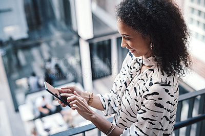 Buy stock photo Shot of a young businesswoman using a smartphone on the stairs of a modern office