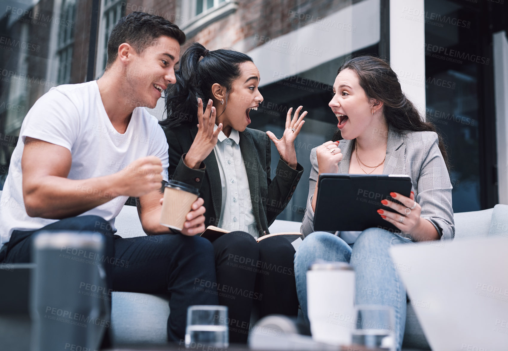 Buy stock photo Shot of a group of excited young businesspeople using a digital tablet during a meeting at a conference