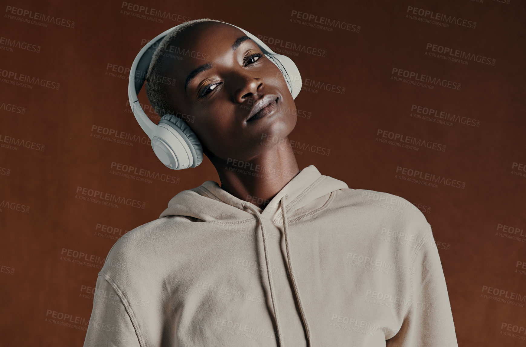 Buy stock photo Black woman, hoodie and headphones for music in studio portrait, training and fitness by background. Person, model and style with jacket, streetwear and streaming with clothes for winter in Nigeria