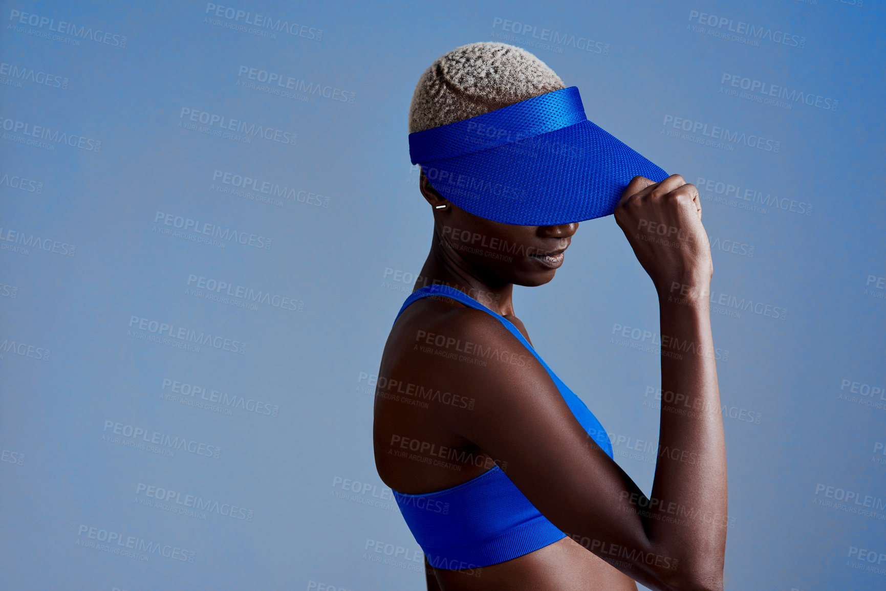 Buy stock photo Black woman, visor or fitness with fashion on space for sport, exercise or training in studio on a blue background. Female person, athlete or model with cap or sportswear for cool accessory on mockup