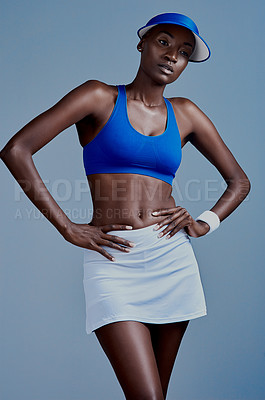 Buy stock photo Studio shot of a sporty young woman wearing a tennis uniform while posing against a grey background