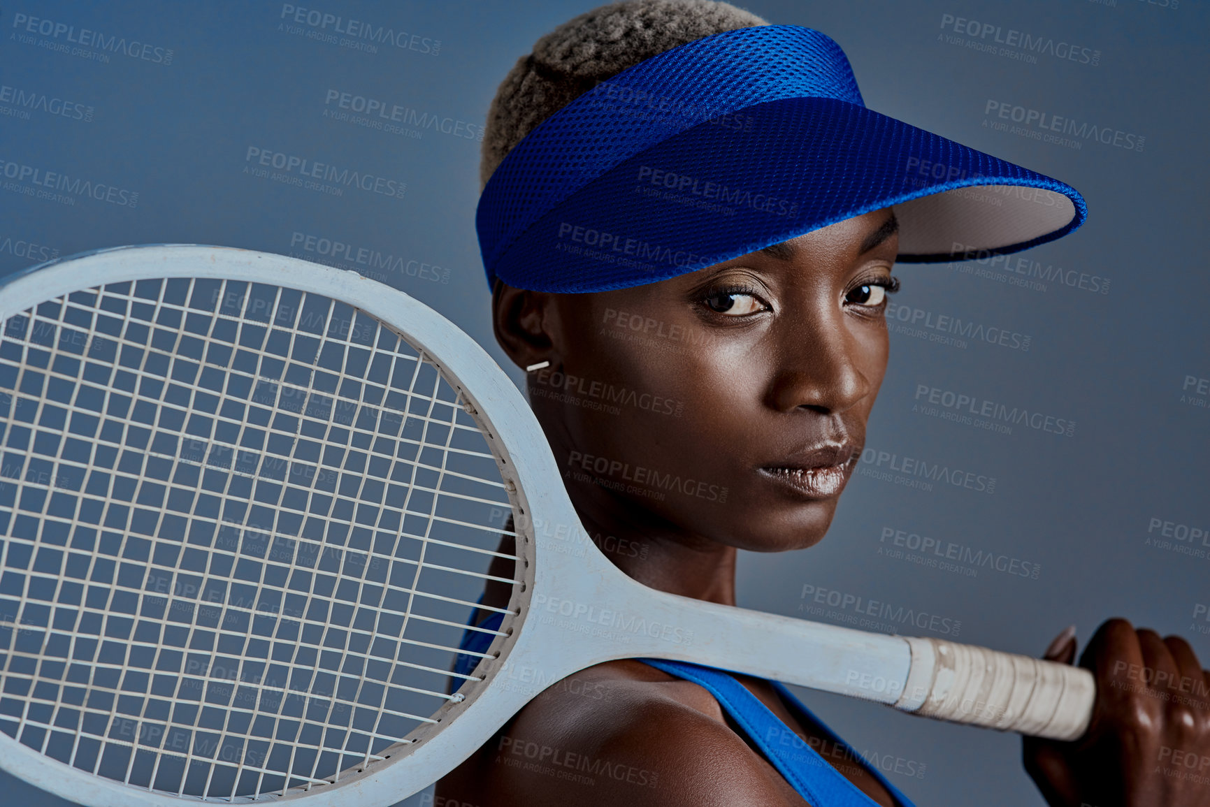 Buy stock photo Studio shot of a sporty young woman posing with a tennis racket against a grey background