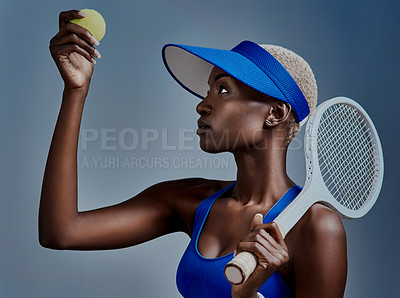 Buy stock photo Studio shot of a sporty young woman posing with tennis equipment against a grey background