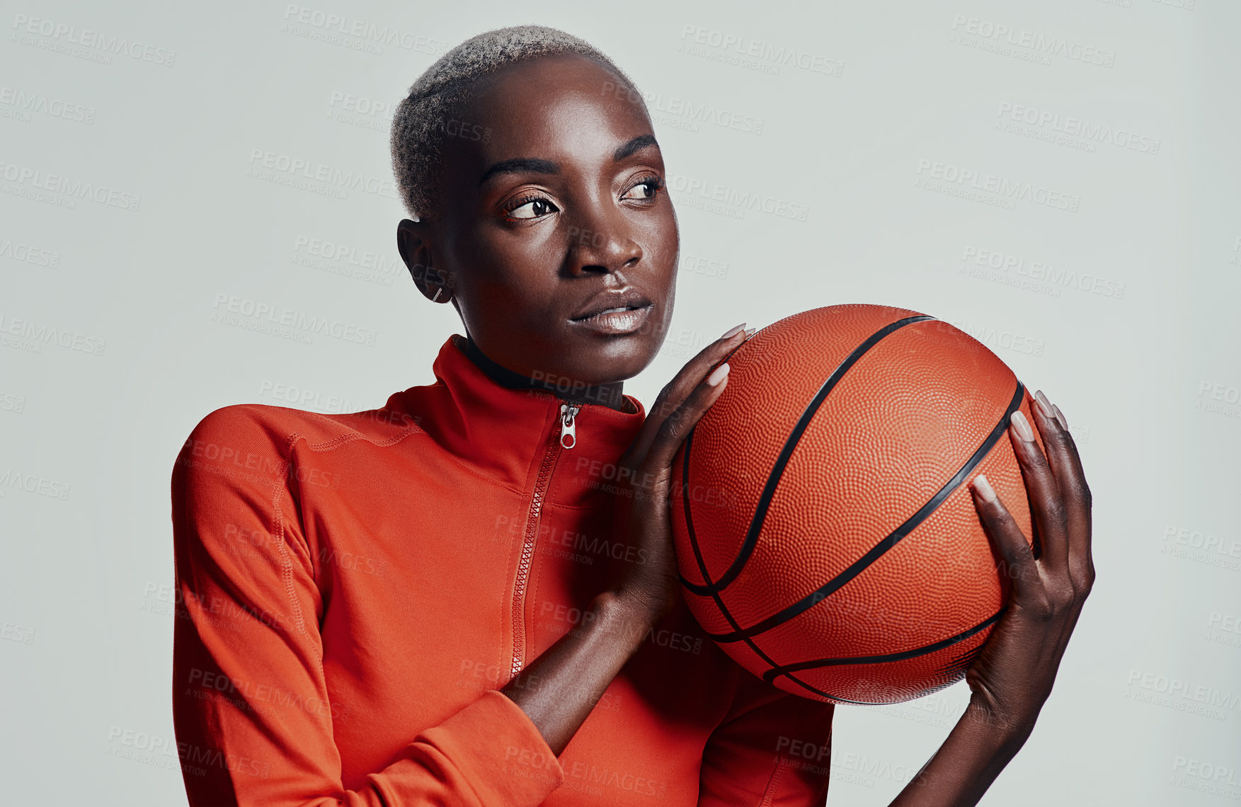 Buy stock photo Studio shot of an attractive young woman playing basketball against a grey background