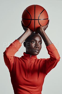 Buy stock photo Studio shot of an attractive young woman playing basketball against a grey background